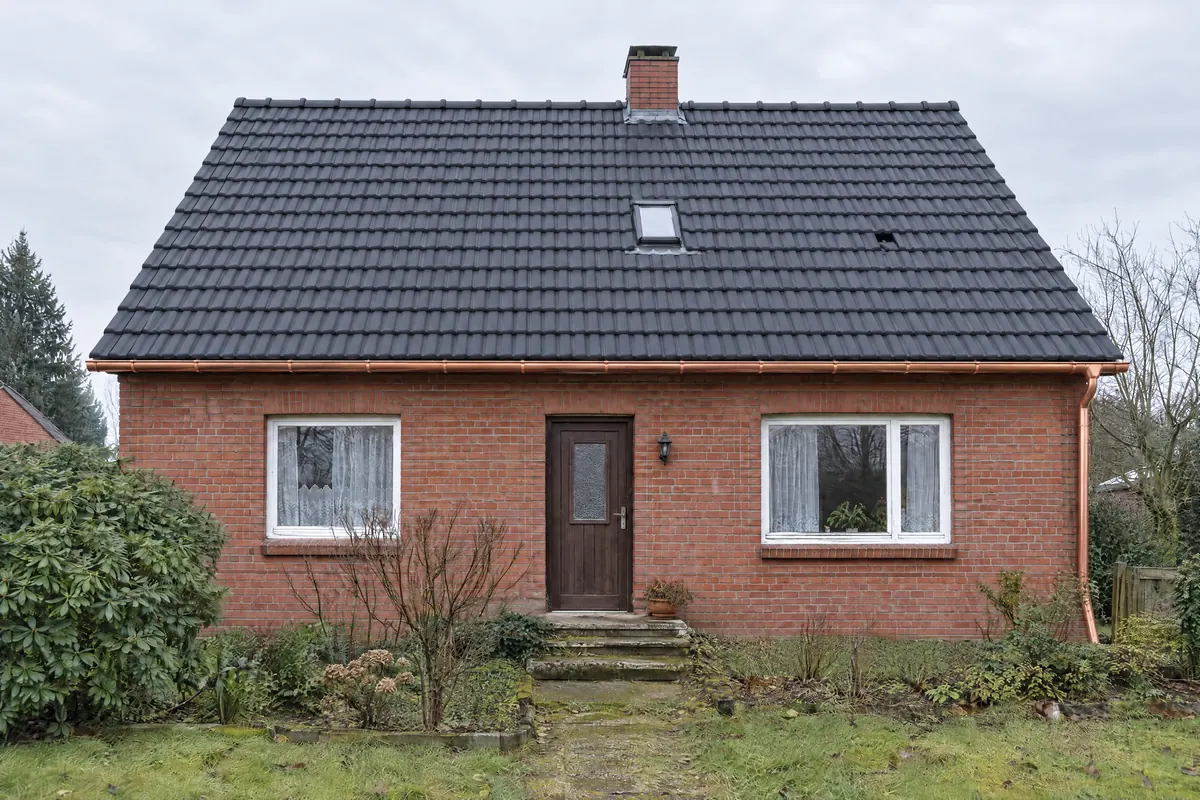 Dasselbe Klinkerhaus nach der Sanierung mit neuem anthrazitfarbenem Dach