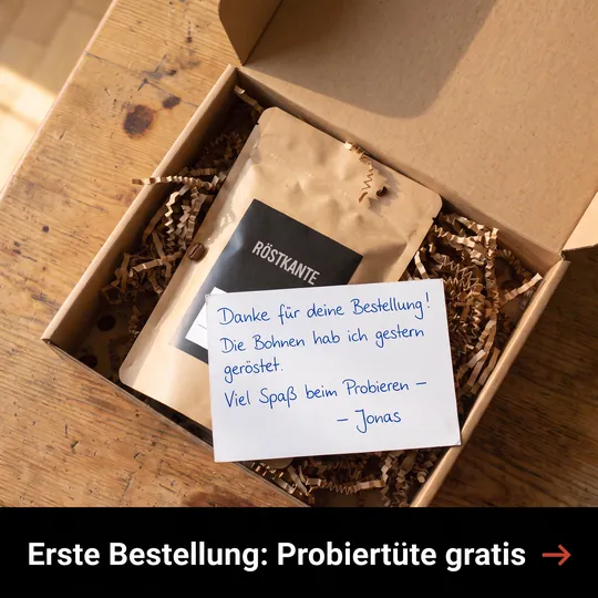 Anzeige mit geöffnetem Paket, Kaffeetüte und handgeschriebener Dankeskarte vom Röster