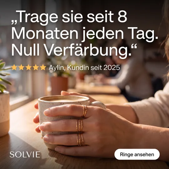Zitat-Anzeige: Hand mit gestapelten Goldringen an einer Kaffeetasse, Zitat einer Kundin